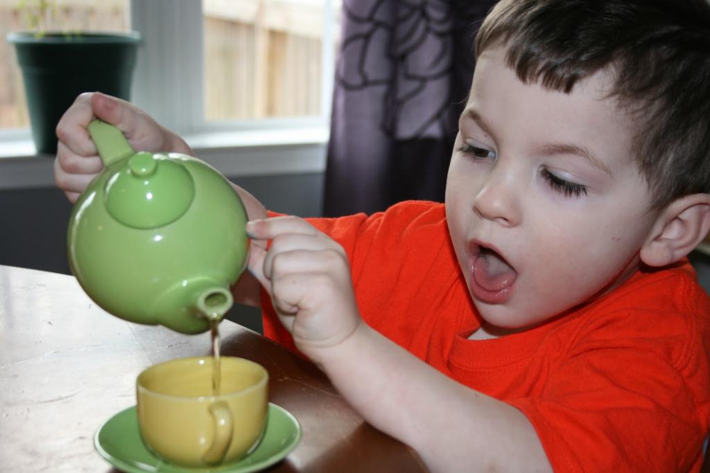 Мальчик наливает чай