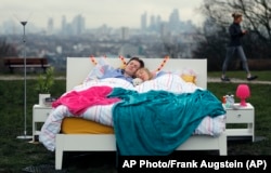 A couple lay in a double bed during a photo opportunity organised by the Mental Health Foundation to mark World Sleep Day, on Parliament Hill, in London, March 15, 2018.