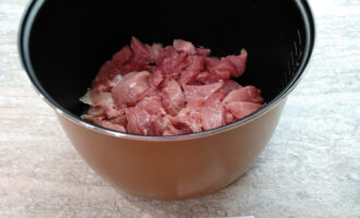 Шаг 2: Промойте говядину и нарежьте ее брусочками. Выложите на дно чаши мультиварки.