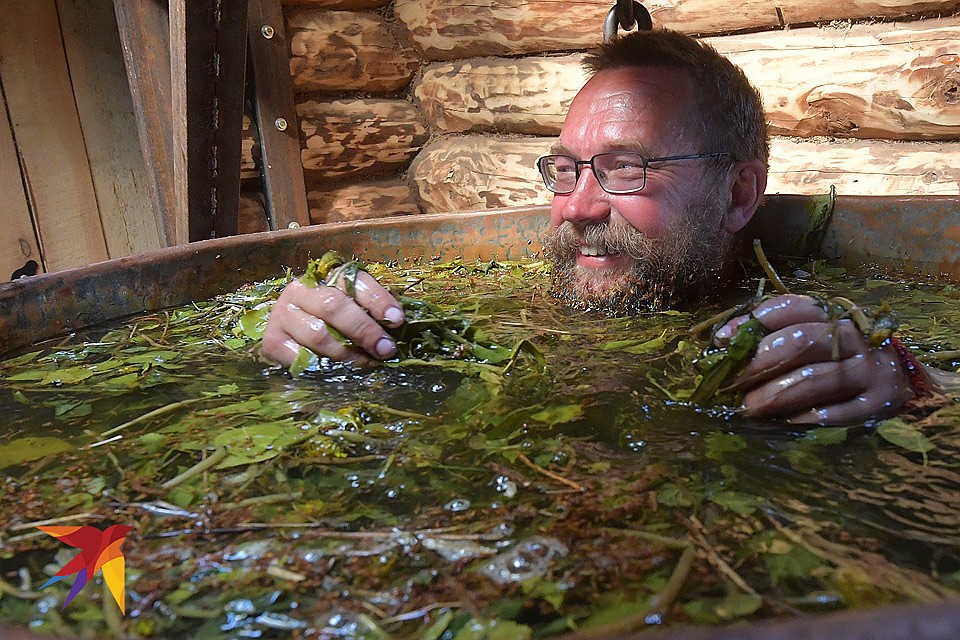 Герман Стерлигов принимает ванну в старинном медном чане, который греется на огне. Фото: Владимир ВЕЛЕНГУРИН