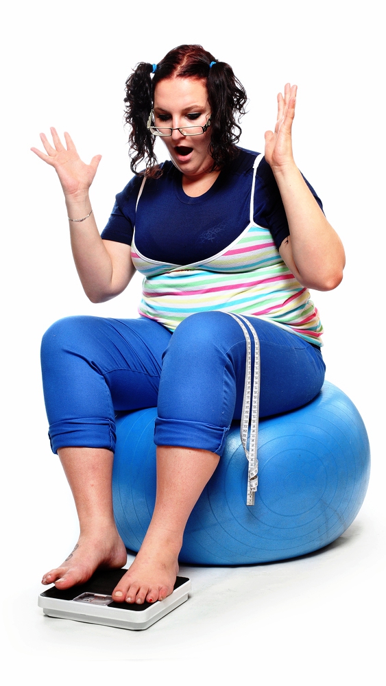 Женщина измеряет свой свой вес, и думает как похудеть сидя на фитболе