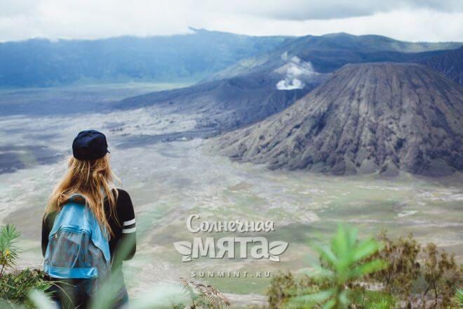 Девушка-турист смотрит на вулкан, фото
