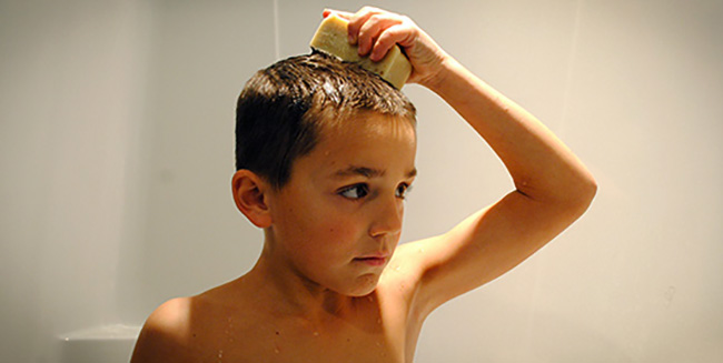 Мальчик моет голову мылом