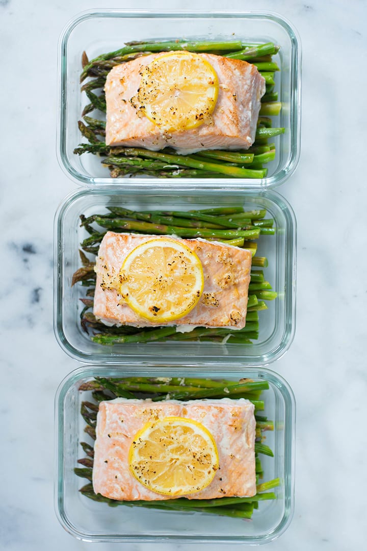 Overhead view of one of the dinners from the meal prep for weight loss, which is asparagus roasted with lemon roasted salmon, organized in meal prep containers.